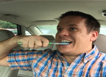 Man brushing teeth while driving