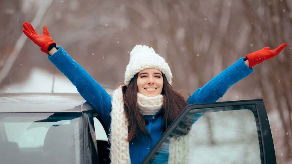 Woman celebrates after buying a car in winter