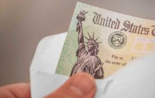 Buying a car during tax season - person's hand holding a envelope and tax refund check