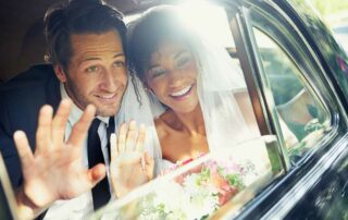 Car Insurance For Married Couples - Couple in car waving on goodbye on wedding day