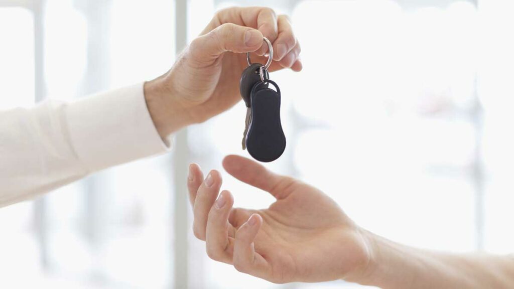 When is the best time to buy a car - person handing off keys