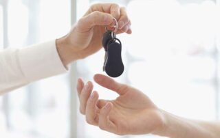 When is the best time to buy a car - person handing off keys