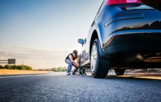 What is Road Hazard Protection - Man changing flat tire