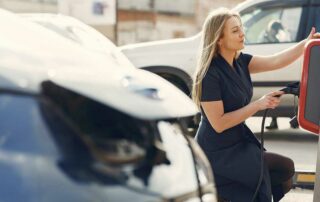 Buying an Electric Car Benefits and Tips - Woman at electric car charging station