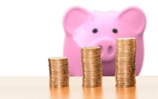 How to lower your car insurance premiums - piggy bank and coin stacks