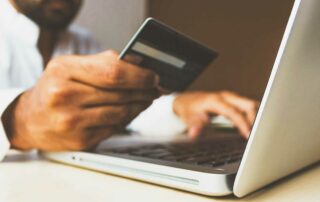 Man with credit card and laptop - credit card budgeting