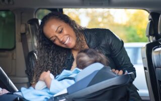 Best family car for car seats - woman with infant in car seat in car