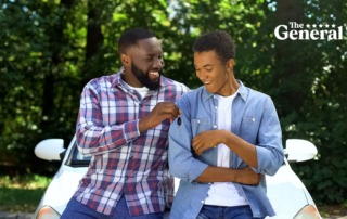Happy dad giving car key to son, permission to drive, parenthood trust, family