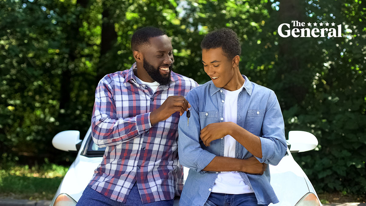 Happy dad giving car key to son, permission to drive, parenthood trust, family