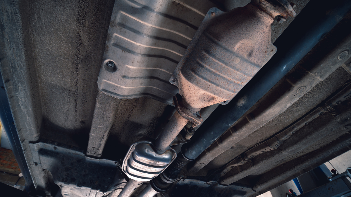 Vehicle underbody exhaust pipe, catalyst, resonator, exhaust system. Old parts require repair and replacement. Car service and maintenance. cardan and outboard bearing