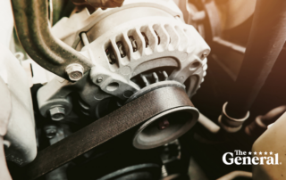 Car alternator from the view beneath a car's hood.