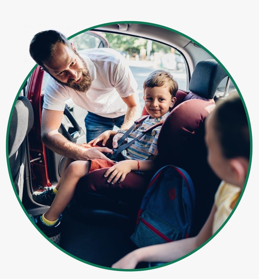 Man buckles his children into booster seats before driving - The General Car Insurance