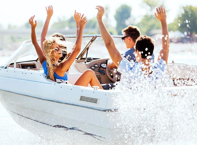 Group of people inside a boat raising their arms - link to The General Labs Boat Insurance page