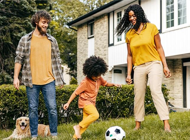 Family playing soccer on front lawn of home - link to The General Labs Home Owner Insurance page