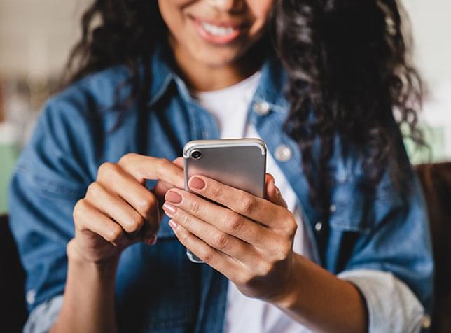Person holding and using a smartphone - link to The General Phone Insurance partner page