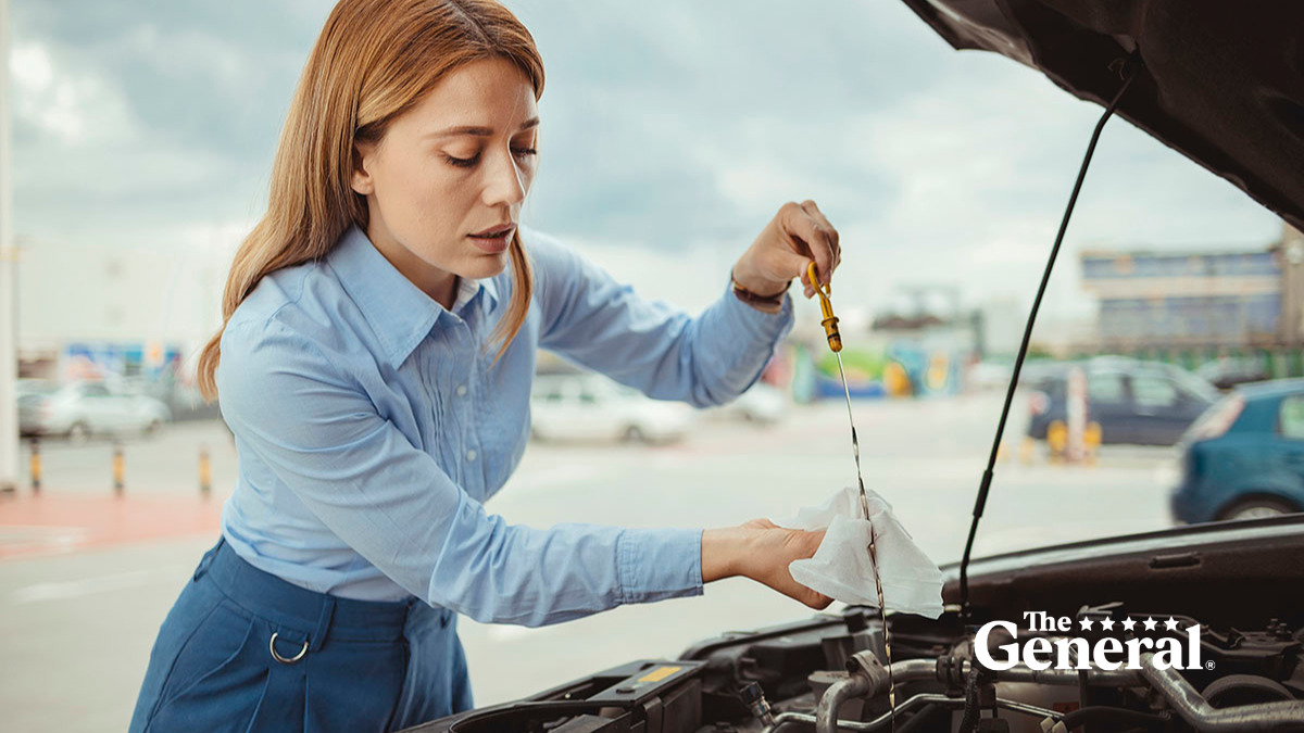 Woman checking her car engine oil