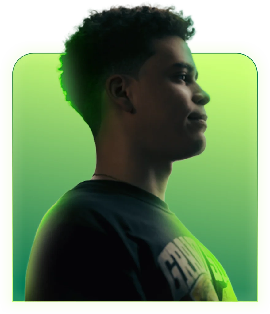Profile portrait of Junior, winner of The General Insurance and WWE Fan of the Year contest, smiling while wearing a black graphic T-shirt against a green gradient background.